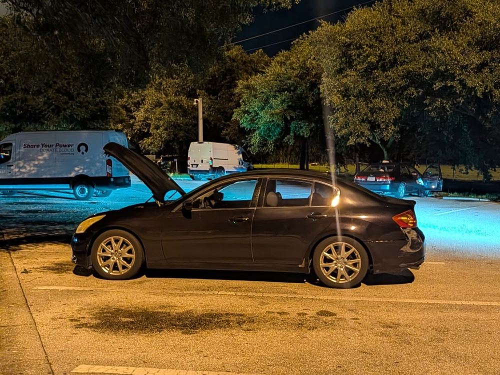 Car worked on after dark with the service van parked behind