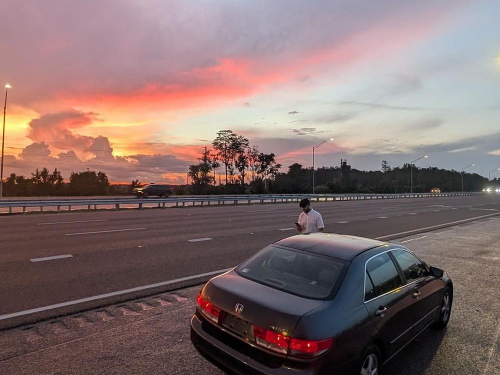 Vehicle stopped on a highway shoulder at sunset