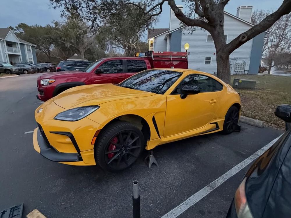 Sports car on a jack at the kerb with tools out